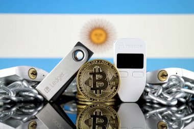 Wroclaw, Polonya - 06 Temmuz 2019: Bitcoin (Btc), Trezor ve Ledger (cryptocurrency donanım cüzdanları), asma kilitler, zincir (Blockchain Technology gibi) ve Arjantin Bayrağı'nın fiziksel sürümü.