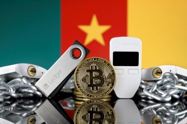 Wroclaw, Polonya - 06 Temmuz 2019: Bitcoin (Btc), Trezor ve Ledger (cryptocurrency donanım cüzdanları), asma kilitler, zincir (Blockchain Teknolojisi gibi) ve Kamerun Bayrağı'nın fiziksel sürümü.