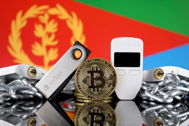 Wroclaw, Polonya - 06 Temmuz 2019: Bitcoin (Btc), Trezor ve Ledger (kriptopara donanım cüzdanları), asma kilitler, zincir (Blockchain Teknolojisi gibi) ve Eritre Bayrağı'nın fiziksel sürümü.