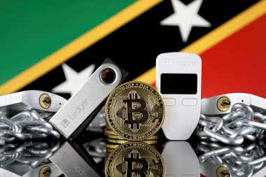 Wroclaw, Polonya - 06 Temmuz 2019: Bitcoin (Btc), Trezor ve Ledger (cryptocurrency donanım cüzdanları), asma kilitler, zincir (Blockchain Teknolojisi gibi) ve Saint Kitts ve Nevis Flag'in fiziksel sürümü.