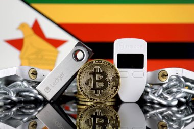 Wroclaw, Polonya - 06 Temmuz 2019: Bitcoin (Btc), Trezor ve Ledger (cryptocurrency donanım cüzdanları), asma kilitler, zincir (Blockchain Teknolojisi gibi) ve Zimbabve Bayrağı'nın fiziksel sürümü.