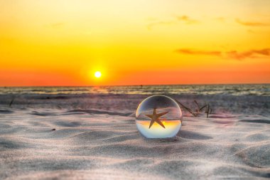 Leba, Polonya yakınlarındaki Slowinski Milli Parkı'nda plajda güzel gün batımı. Bir cam, kristal top (lensball) kırılma fotoğraf için bir denizyıldızı görünümü. Vahşi, el değmemiş doğa.