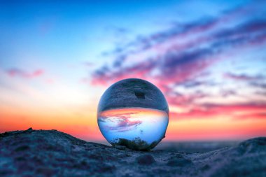 Leba, Polonya yakınlarındaki Slowinski Milli Parkı'nda plajda güzel gün batımı. Bir cam, kristal top (lensball) kırılma fotoğraf için bir denizyıldızı görünümü. Vahşi, el değmemiş doğa.