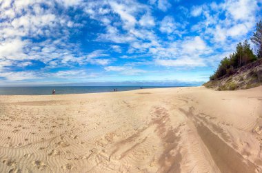 Leba, Polonya - 24 Temmuz 2019: Baltık Denizi kıyısında, Polonya'nın Leba kenti yakınlarındaki Slowinski Ulusal Parkı. Leba ve Hareketli Tepeler arasındaki yürüyüş parkurunda güzel kumlu plajlar ve sahil manzarası.
