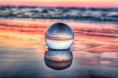 Leba, Polonya yakınlarındaki Slowinski Milli Parkı'nda plajda güzel gün batımı. Kırılma fotoğrafçılığı için bir cam, kristal küre (lensball) ile görüntüle. Vahşi, el değmemiş doğa.