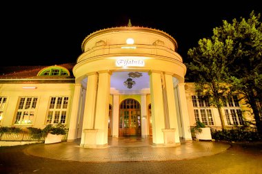 Polanica Zdroj, Polonya - 26 Ağustos 2019: Polanica Zdroj'un merkezindeki spa parkı, Aşağı Silezya, Güneybatı Polonya. Tarihi maden suyu pompası odası ile Spa tesisi. Gece görünümü.