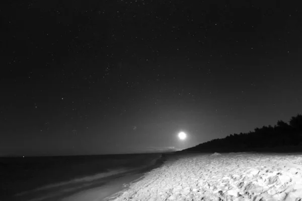 Slowinski National Park on the Baltic Sea coast, near Leba, Poland. Night view, starry sky right after the moon rising. Beautiful sandy beaches and coastal landscape.