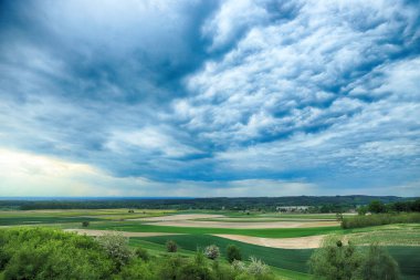 Güzel, yeşil tarlalar ve Mayıs sonunda bulutlu gökyüzü. Wroclaw, Polonya, Avrupa yakınlarındaki Trzebnica tepelerinden görüntü.