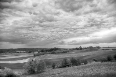 Mayısın sonunda güzel tarlalar ve bulutlu gökyüzü. Wroclaw, Polonya, Avrupa yakınlarındaki Trzebnica tepelerinden görüntü. Siyah beyaz fotoğraf..