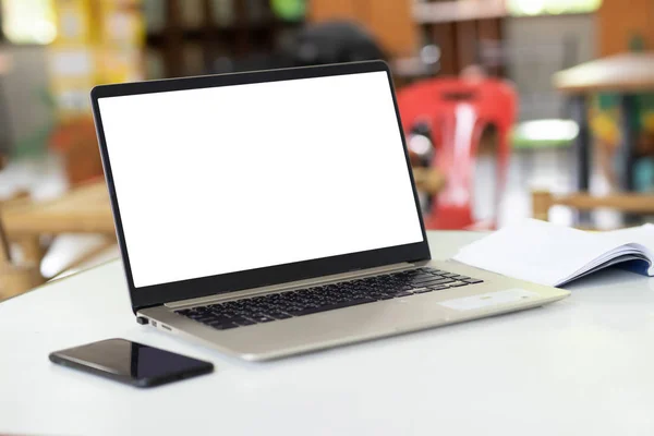 Notebook computers have a white background screen  Placed on the table, blurred background