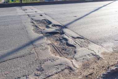 Güneşli bir günde kırık asfalt yol