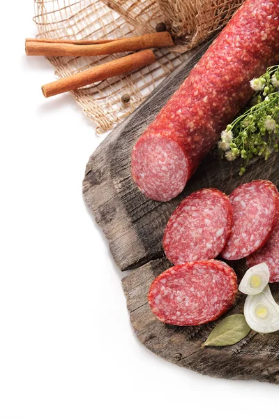 Vida tranquila com salsicha defumada, folha de louro de salame e cebola em uma textura envelhecida de madeira em um fundo branco — Fotografia de Stock