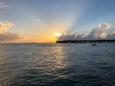 yelkenli ve jet ski ile okyanusta çarpıcı gün batımı