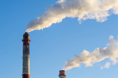 endüstriyel baca üzerinde mavi gökyüzünün dumanı