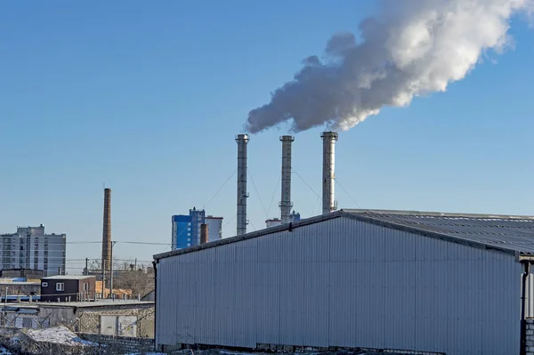 industrial smoke from chimney on blue sky