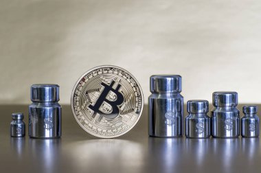 Cryptocurrency ağırlığını ve maliyetini azaltarak kavramı. Ağırlıklar ile Bitcoin ve doları, büyüme ve düşüş gösteren sembollerin kazınmış.
