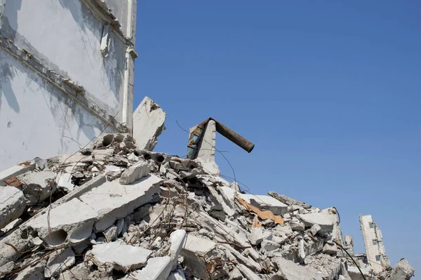 Resterna av den förstörda byggnaden av en stor industriell anläggning på bakgrund av blå himmel. Bakgrund — Stockfoto