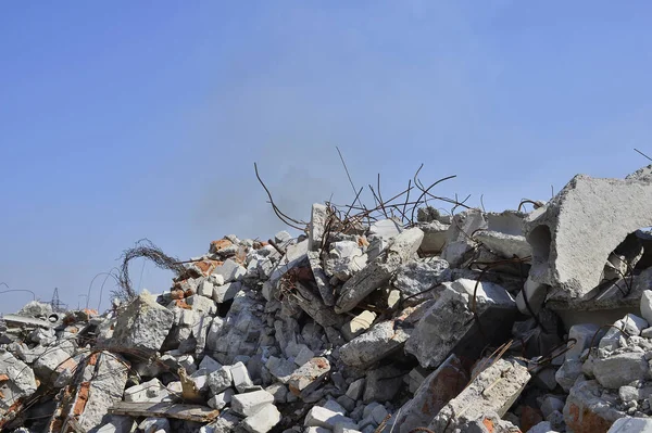 Rebar는 벽돌 잔해 더미에서 편을. 백그라운드에서 연기 클럽의 잔재를 볼 수 있습니다. — 스톡 사진