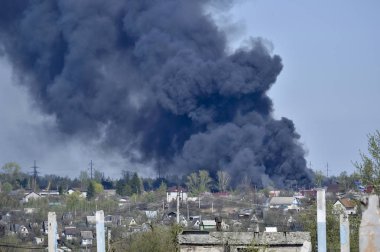 İnşaat demiri arka planda kalın siyah duman mavi gökyüzünde çıkıntılı beton moloz yığını. Arka plan. İnsan faaliyetlerinin sonuçlarını kavramı.