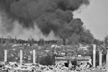 İnşaat demiri arka planda kalın siyah duman gökyüzünde çıkıntılı beton moloz yığını. Arka plan. İnsan faaliyetlerinin sonuçlarını kavramı. Siyah beyaz resim.