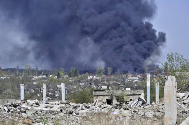 İnşaat demiri arka planda kalın siyah duman mavi gökyüzünde çıkıntılı beton moloz yığını. Arka plan. İnsan faaliyetlerinin sonuçlarını kavramı.