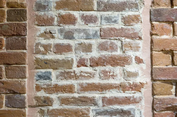 Part of the red brick wall with a window of an old house. Background.