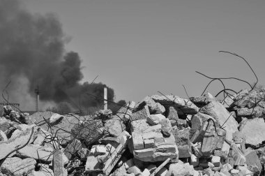 İnşaat demiri arka planda kalın siyah duman gökyüzünde çıkıntılı beton moloz yığını. Arka plan. İnsan faaliyetlerinin sonuçlarını kavramı. Siyah beyaz resim.