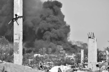 İnşaat demiri arka planda kalın siyah duman mavi gökyüzünde çıkıntılı beton moloz yığını. Arka plan. İnsan faaliyetlerinin sonuçlarını kavramı. Siyah beyaz resim.