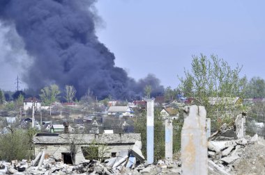 İnşaat demiri arka planda kalın siyah duman mavi gökyüzünde çıkıntılı beton moloz yığını. Arka plan. İnsan faaliyetlerinin sonuçlarını kavramı.