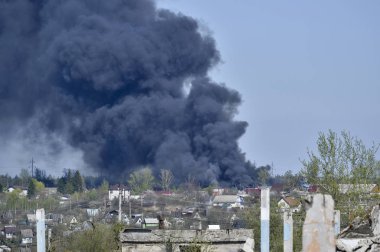 İnşaat demiri arka planda kalın siyah duman mavi gökyüzünde çıkıntılı beton moloz yığını. Arka plan. İnsan faaliyetlerinin sonuçlarını kavramı.