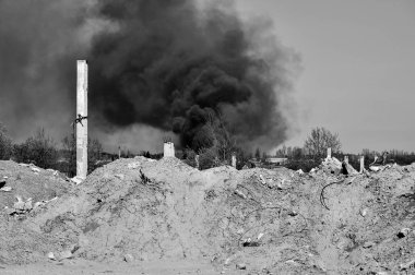 İnşaat demiri arka planda kalın siyah duman gökyüzünde çıkıntılı beton moloz yığını. Arka plan. İnsan faaliyetlerinin sonuçlarını kavramı. Siyah beyaz resim.