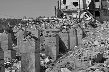 Büyük bir yapının tahrip kazık, taş, toprak ve kil şeklinde beton temeli kalıntıları. Siyah ve beyaz.