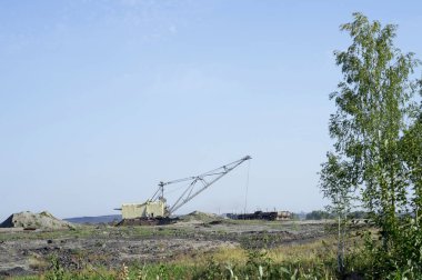 Büyük bir ekskavatör boş tren kaya taşır. Üçüncü dünya ekonomisi kavramı: madencilik ve çevre sorunları. Doğa adam tarafından imha sonra sanayi peyzaj.