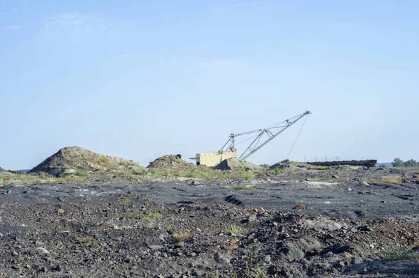 Büyük bir ekskavatör boş tren kaya taşır. Üçüncü dünya ekonomisi kavramı: madencilik ve çevre sorunları. Doğa adam tarafından imha sonra sanayi peyzaj.