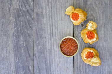 Eklerleri ahşap rustik antika arka plan üzerinde kırmızı havyar ile.