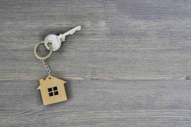 Metal tuş kilidi bambu Anahtarlık ahşap rustik gri arka plan için evde. Emlak satın alma teklifi kavramı. Kopya alanı.