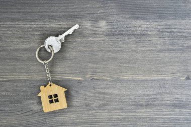 Metal tuş kilidi bambu Anahtarlık ahşap rustik gri arka plan için evde. Emlak satın alma teklifi kavramı. Kopya alanı.