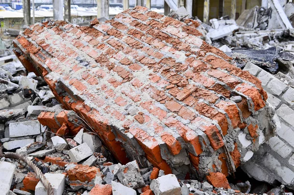 Bir beton bina kalıntıları. Kırmızı tuğla closeup moloz yığını içinde yalan duvar parçası.