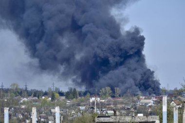 İnşaat demiri arka planda kalın siyah duman mavi gökyüzünde çıkıntılı beton moloz yığını. Arka plan. İnsan faaliyetlerinin sonuçlarını kavramı.