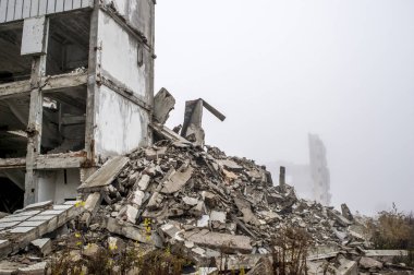 Gri beton kazık ve taşlar yıkılan binanın enkazı büyük bir yığın. İmha etkisi. Arka plan.