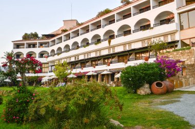 Hotel coral Bay Pafos, Kıbrıs, Haziran 2017 cephe. Teraslar, çalılar ve ağaçlar çalılıkları ile cvetochik.
