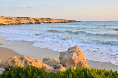 Akdeniz ıssız sahilde turuncu günbatımı.
