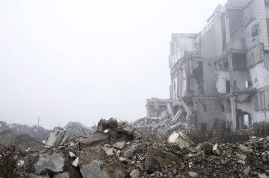 Sisli bir sis yıkılan binanın arka planda gri taş beton parçaları kalıntıları. Kopya alanı