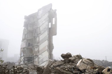 Sisli bir sis yıkılan binanın arka planda gri taş beton parçaları kalıntıları. İmha etkisi. Arka plan.