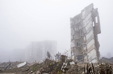 Sisli bir sis yıkılan binanın arka planda gri taş beton parçaları kalıntıları. Kopya alanı