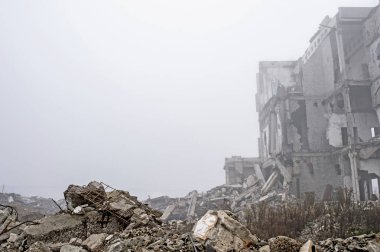 Sisli bir sis yıkılan binanın arka planda gri taş beton parçaları kalıntıları. Kopya alanı