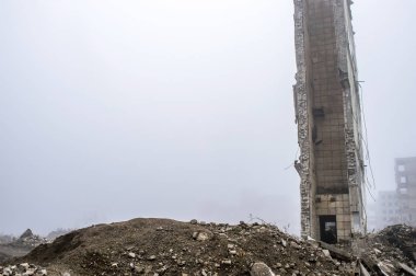 Büyük bir duvar kalıntıları Binası yıkılan binada bir sisli sis ve ön planda moloz yığını, arka planı yok. Kopya alanı.