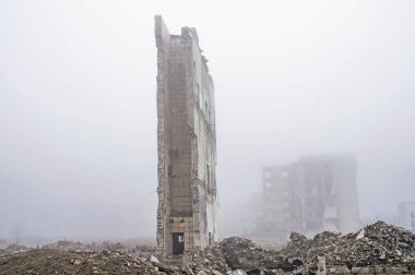 Büyük bir duvar kalıntıları Binası yıkılan binada bir sisli sis ve ön planda moloz yığını, arka planı yok. Kopya alanı.