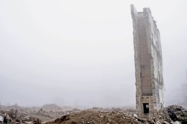 Büyük bir duvar kalıntıları Binası yıkılan binada bir sisli sis ve ön planda moloz yığını, arka planı yok. Kopya alanı.