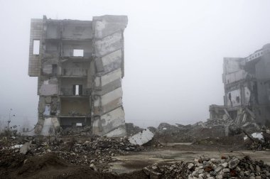 Sisli bir sis yıkılan binanın arka planda gri taş beton parçaları kalıntıları.